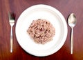 Gaba rice in a dish made of recycled materials on a wooden table with cutlery placed