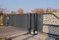 Gabion. Automatic entrance gate used in combination with a wall made of gabion