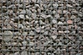 Gabion close up - grey pebble stones behind metal grate, abstract background
