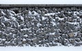 Gabion, texture, background. Snow covered gabion net and stone fencing design Royalty Free Stock Photo