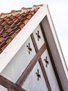 Gable of an old historical house with tiles, wooden details and crosses Royalty Free Stock Photo