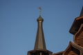 Gabled high conical roof with gilded dome and cross, part of an old wooden Christian Orthodox church