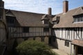 gabled roof and half-timbering of tudor house, with view toward courtyard