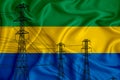 Gabon flag in the background Conceptual illustration and silhouette of a high voltage power line in the foreground a symbol of the Royalty Free Stock Photo