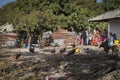 People gather near a house in a slum in the outskirts of the city of Gabu, with dirt in the street and vultures, in Guinea-Bissau