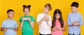 Gadget addiction. Children with modern gadgets, yellow background
