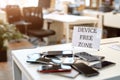 Gadgets aren`t welcome here. Close up of mobile phones on the office table with device free zone sign