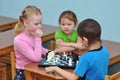 Children play chess at a table in a kindergarten group