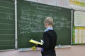 The pupil performs the task at the school board at the lesson of the Russian language