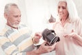 Gaged interested man standing and holding VR glasses. Royalty Free Stock Photo