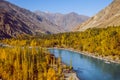 Gahkuch in autumn show river flow through colorful forest and surrounded by mountains in karakoram range.