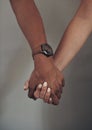 We gain comfort from each other. an unrecognizable couple standing together against a grey wall indoors and holding Royalty Free Stock Photo