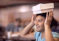 Gaining book smarts. A smiling student with his books balanced on his head - copy space.