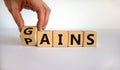 Gains and pains symbol. Businessman turns wooden cubes, changes word pains to gains. Beautiful white background. Business, pains Royalty Free Stock Photo