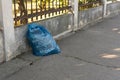 GalaÃâºi, Romania - September 14, 2022: Plastic trash bag on the sidewalk. Closed plastic bag with the logo of the company for