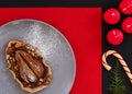 Galetta - homemade autumn pear cookies with cinnamon and creamy caramel on a ceramic plate on a red background. Thuja branches,