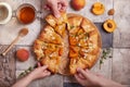 Galette with apricots, brown sugar and almond petals. Family sharing a dessert