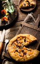 Galette with cheese on wooden table.