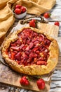 Galette with strawberry and rhubarb. Homemade tart, tarte. White wooden background. Top view Royalty Free Stock Photo
