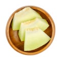 Galia melon slices, also known as sarda melon, in a wooden bowl