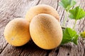 Galia melons with green leaves on wooden table Royalty Free Stock Photo