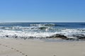 Beach with rocks and small waves breaking. Blue sea with foam, sunny day. Galicia, Spain. Royalty Free Stock Photo