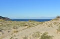 Sand dunes with grass and vegetation on a beach with blue sea. Sunny day, clear sky, Galicia, Spain. Royalty Free Stock Photo