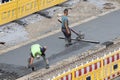 Workers working on a city road polishing concrete on a construction site