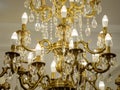 Beautiful golden chandelier with candles close-up hanging on the ceiling