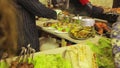 Gallant seller dressed in a suit putting food in plate. Street vendor cooking