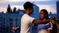 Gallant teenage boy putting shirt on girlfriend, showing care and protection