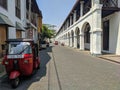 Galle, Sri Lanka - March 12, 2022: View of the street and architecture of the old town of Galle. Red tuk-tuk is parked outside a Royalty Free Stock Photo