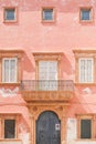 Gallipoli, Apulia - A pink facade with a barn door and several w