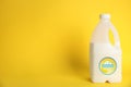 Gallon bottle of banana milk on yellow background, space for text. Vegan product Royalty Free Stock Photo