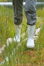 Galoshes, woman going in rubber boots in a meadow