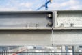 Galvanized bolted connection of steel elements of framework with blue tower crane in background Royalty Free Stock Photo