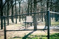 Galvanized vinyl-coated chain link fences, steel posts and panels dog park surrounding by woods bare trees at rest area public