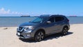 GALVESTON, TEXAS, USA - JUNE 8, 2018: A charcoal grey colored Nissan Rogue compact crossover SUV car is parked on the beach.