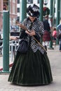 Galveston, TX/USA - 12 06 2014: Lady dressed in Victorian style texting on the phone at Dickens on the Strand Festival in Galvesto Royalty Free Stock Photo