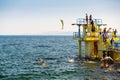 Galway city, Ireland - 24.04.2021: Girl and a woman jumping off Blackrock diving board into Atlantic ocean water. high tide, Clear Royalty Free Stock Photo