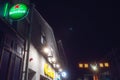 Galway, Ireland -12.06.2021 Illuminated Heineken sign in focus. Centra shop and Christmas decorations. Night shot and