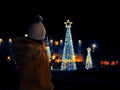 Young girl teenager taking picture on her smart phone of Christmas decorated trees. Selective focus. Royalty Free Stock Photo