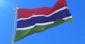 Flag of Gambia waving at wind in slow in blue sky, loop