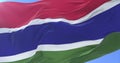 Gambian flag waving at wind in slow in blue sky, loop