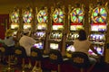 Gamblers putting coins into slot machines in Las Vegas, NV Royalty Free Stock Photo