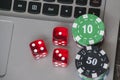 Gambling chips and red dice on laptop keyboard background Royalty Free Stock Photo