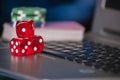 Gambling chips and red dice on laptop keyboard background Royalty Free Stock Photo