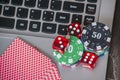 Gambling chips and red dice on laptop keyboard background Royalty Free Stock Photo
