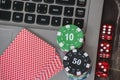 Gambling chips and red dice on laptop keyboard background Royalty Free Stock Photo