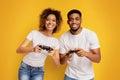 Gambling couple playing video game with joysticks,